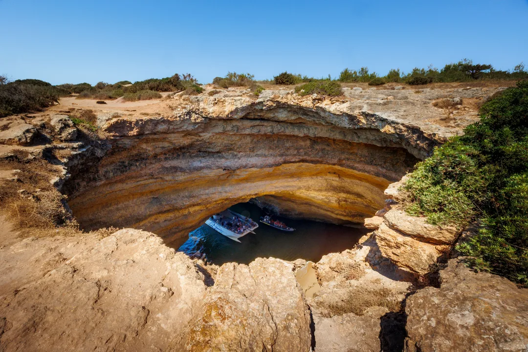 Boats floating inside the Benagil sea cave skylight in the Algarve