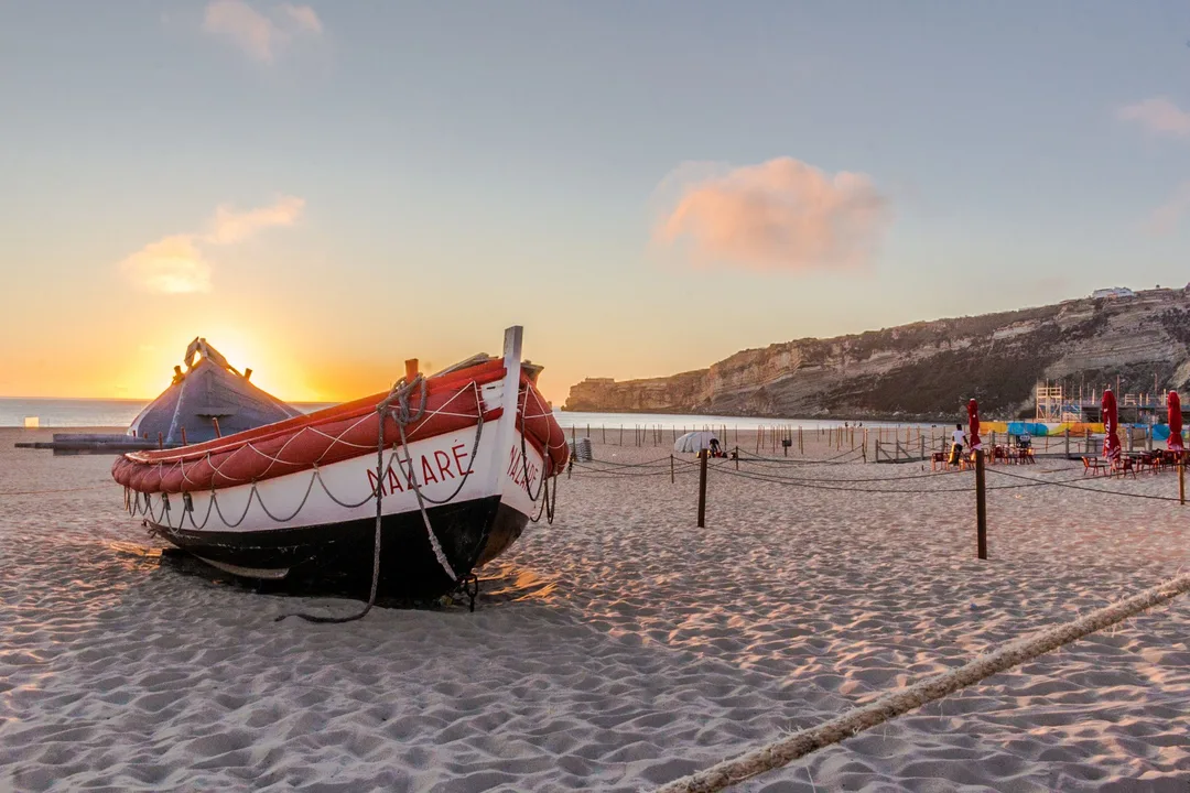 Traditional fishing boat on Nazaré beach at sunset