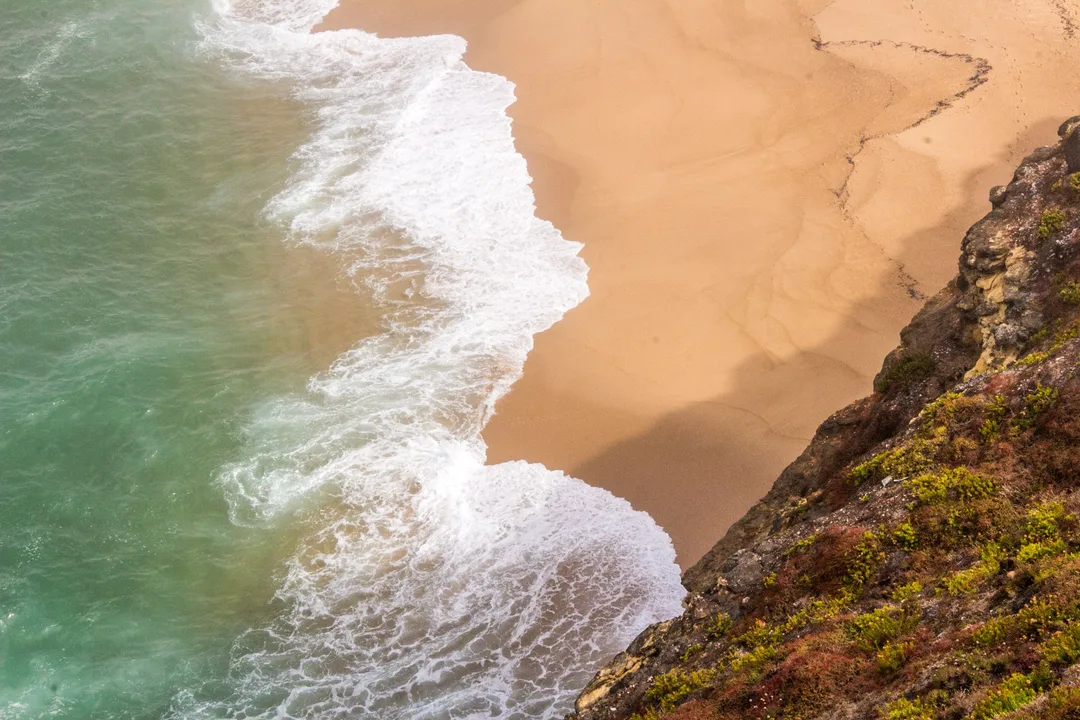Atlantic waves breaking beneath cliffs on the Nazaré coast