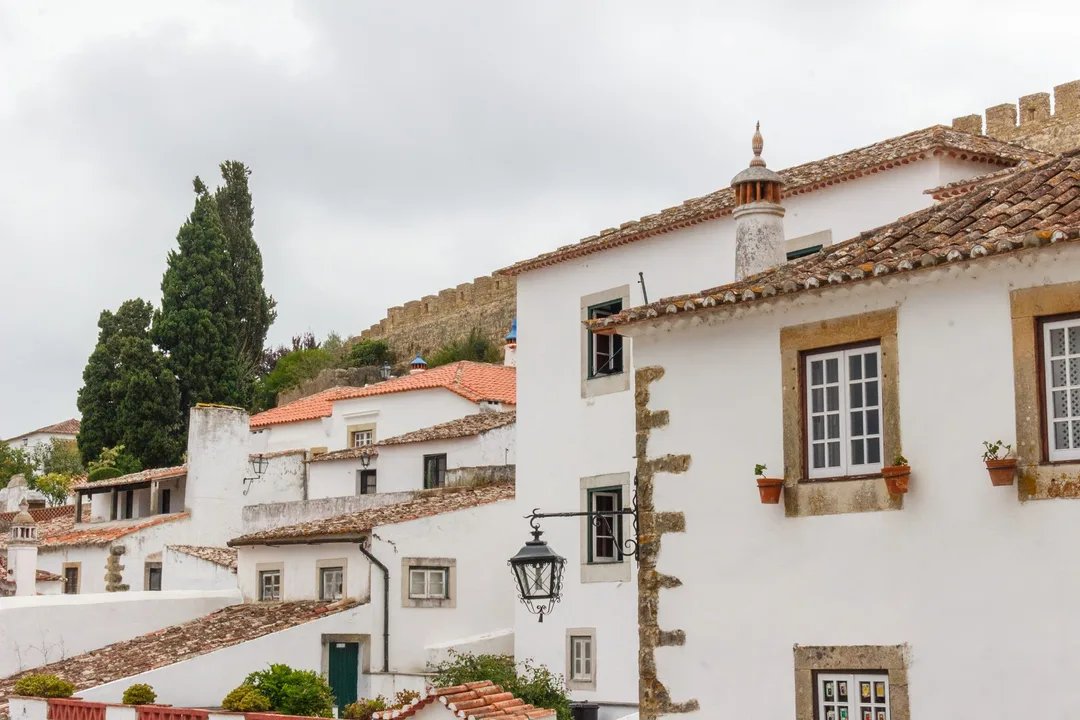 Whitewashed houses and castle walls rising above Óbidos