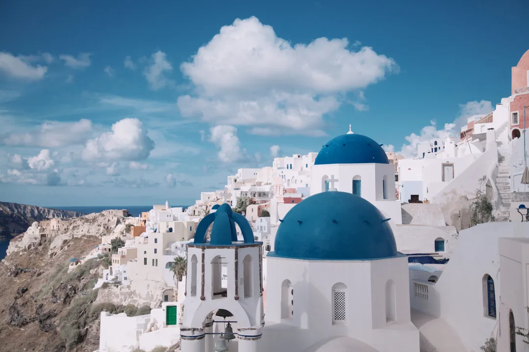 Blue-domed churches above whitewashed houses in Oia Santorini