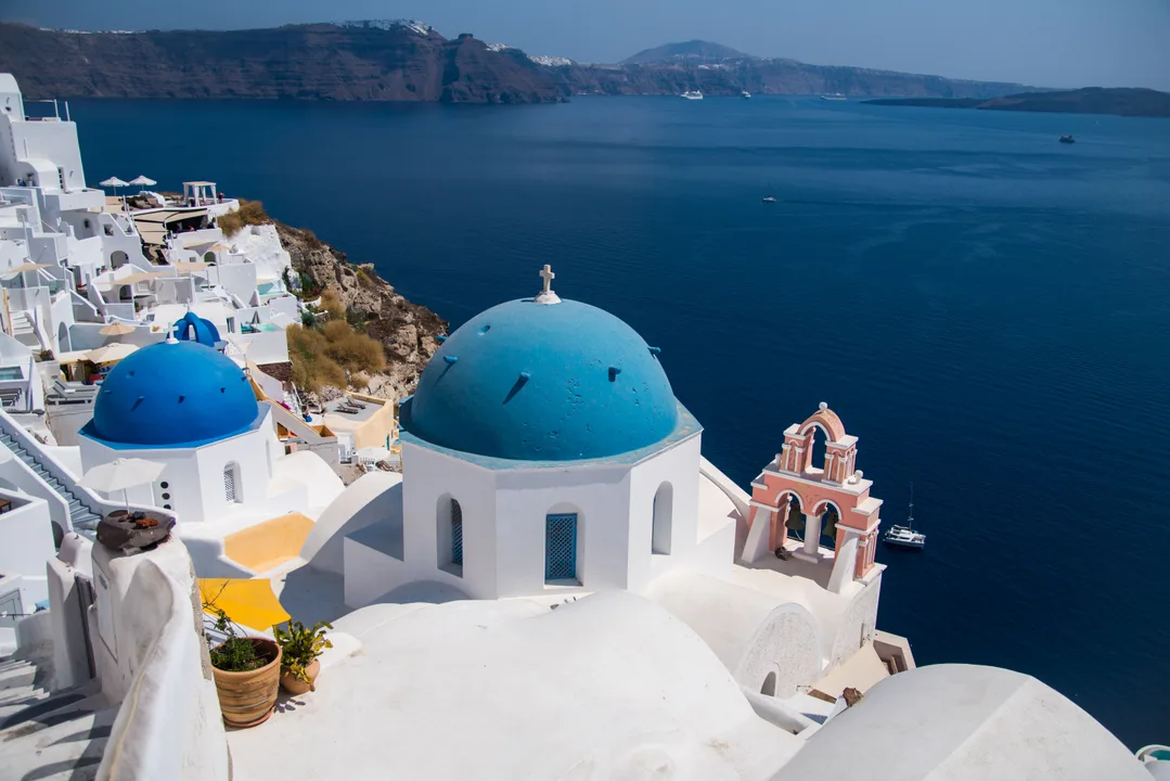 Santorini caldera view with white buildings and blue domes overlooking the Aegean Sea