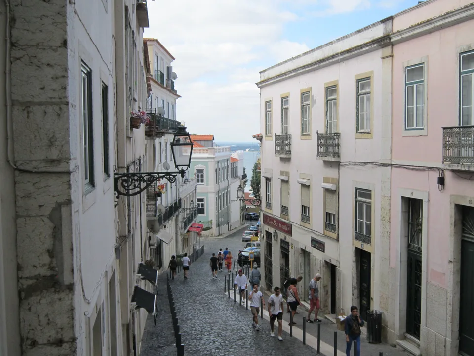 Narrow cobblestone lane lined with tiled facades in Alfama, Lisbon