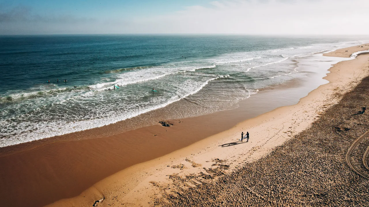 Surfers on the long sand beach at Carcavelos near Lisbon